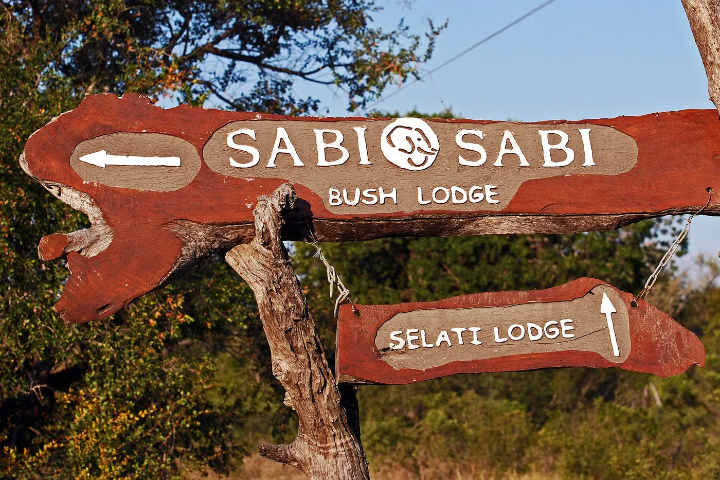 Wooden signpost reading Sabi Sabi Bush Lodge, with a second sign pointing to Selati Lodge