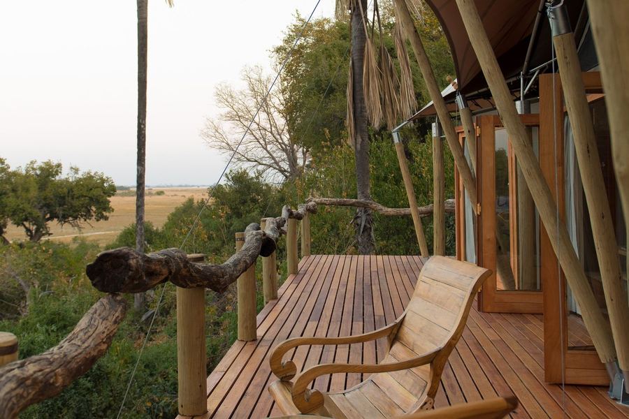Wooden armchairs on the raised timber deck of a safari lodge